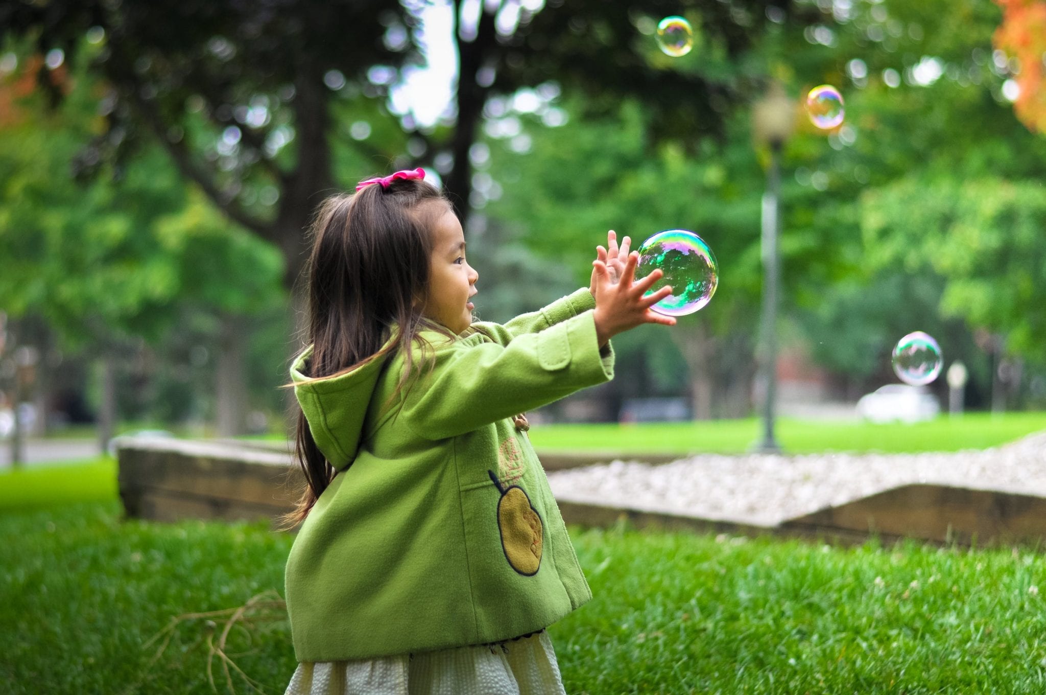 child reaching towards large bubble